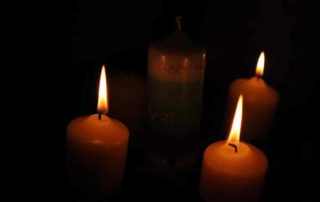 Julkranz mit drei brennenden Kerzen