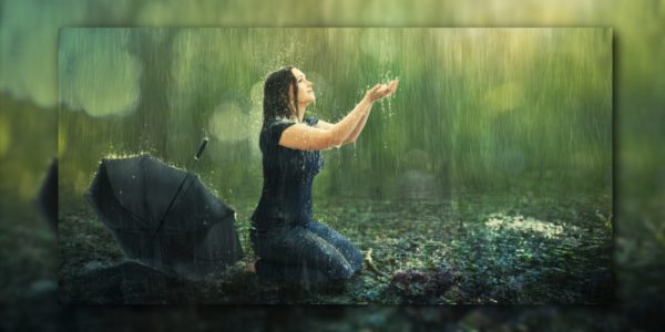 Frau kniet im Regen
